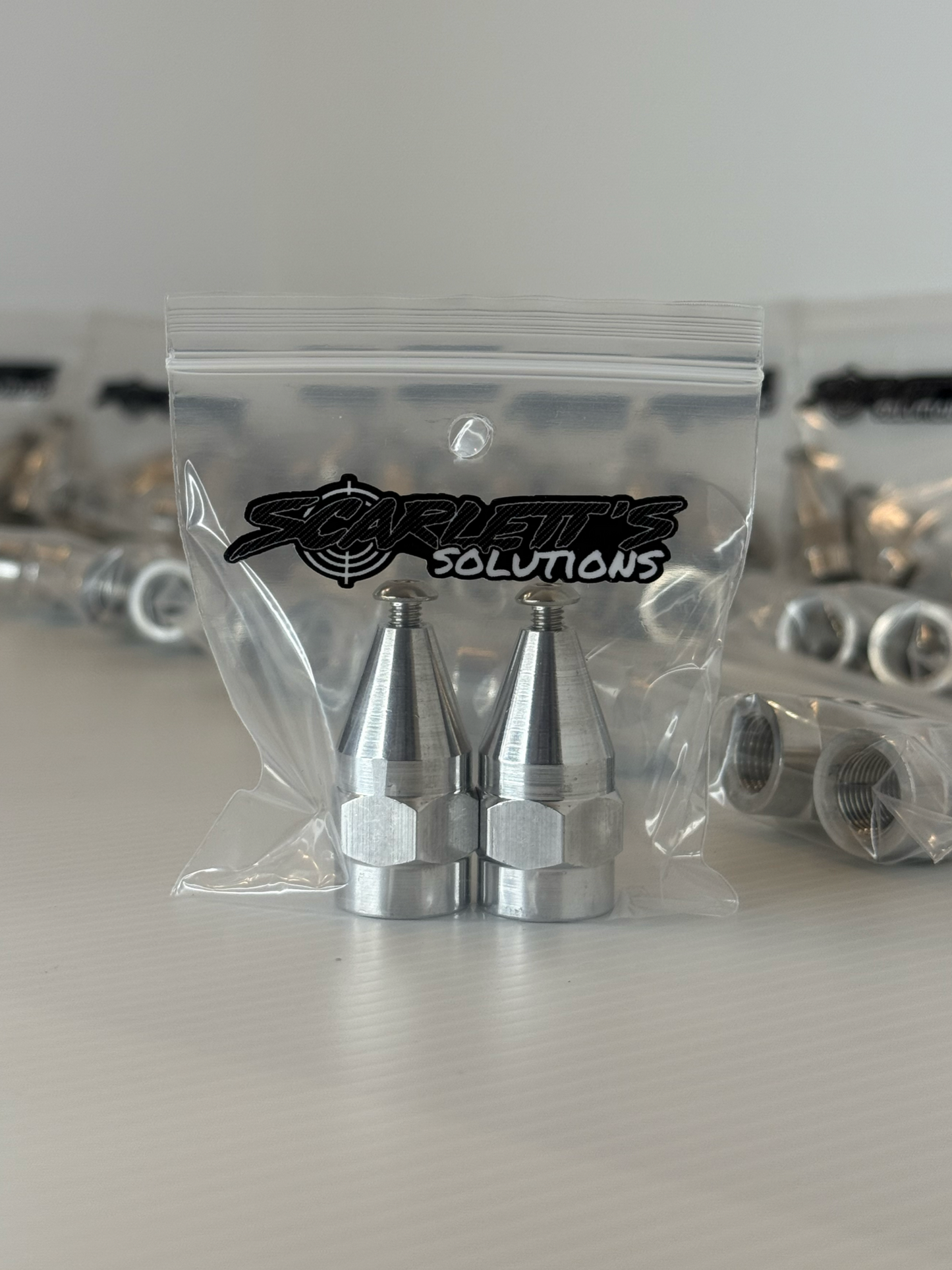 Pair of aluminum shock sensor nuts in packaging from Scarlett's Solutions, designed for 1/2-20 shock bolts.